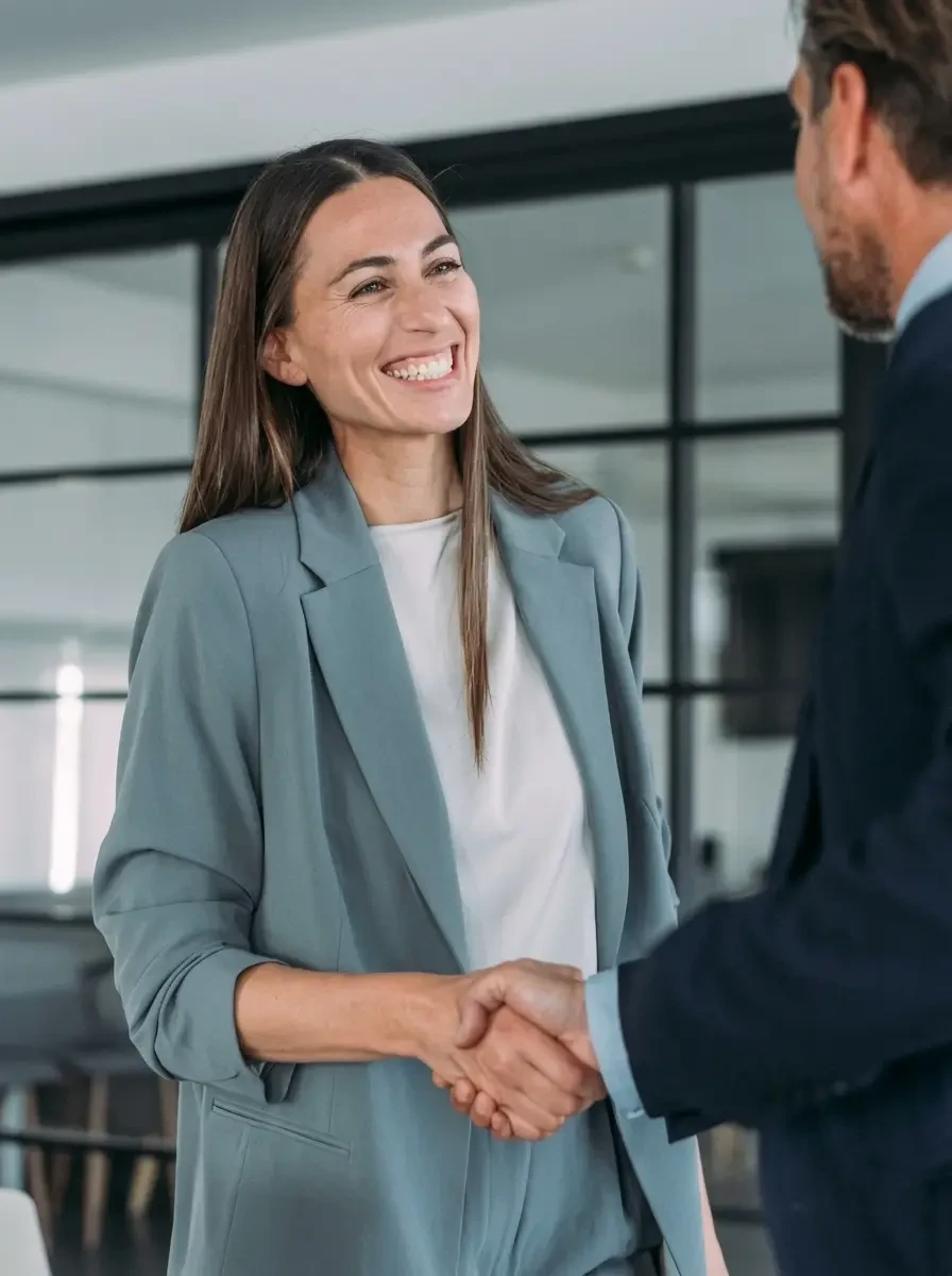 Une chargée de partenariat serre la main d'un partenaire
